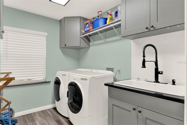 9642 Bear Lake Rd, Apopka, FL 32703 - washroom with cabinet space, a sink, baseboards, wood finished floors, and washer and clothes dryer