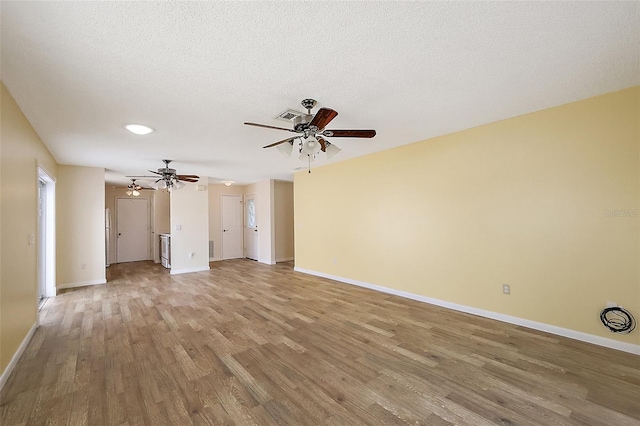1323 Balboa Ct, The Villages, FL 32159 - unfurnished living room featuring light wood-style floors, ceiling fan, visible vents, baseboards, and a textured ceiling