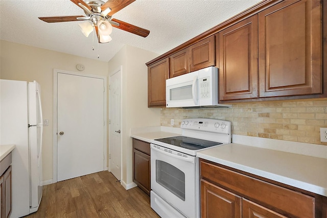 1323 Balboa Ct, The Villages, FL 32159 - kitchen featuring tasteful backsplash, white appliances, light countertops, dark wood-style flooring, and a ceiling fan