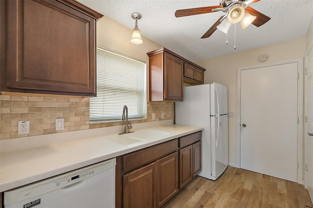 1323 Balboa Ct, The Villages, FL 32159 - kitchen featuring a sink, ceiling fan, light wood-type flooring, backsplash, and white appliances