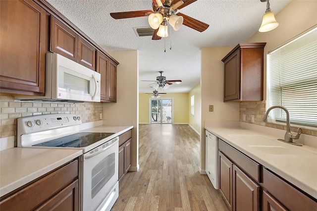 1323 Balboa Ct, The Villages, FL 32159 - kitchen with tasteful backsplash, white appliances, ceiling fan, and a sink