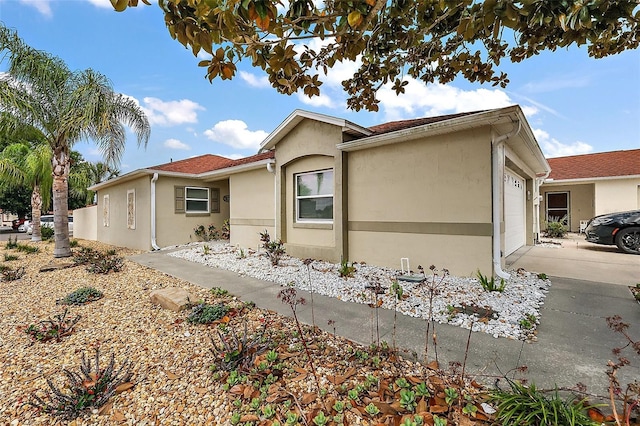 1323 Balboa Ct, The Villages, FL 32159 - view of side of property with stucco siding, concrete driveway, and a garage
