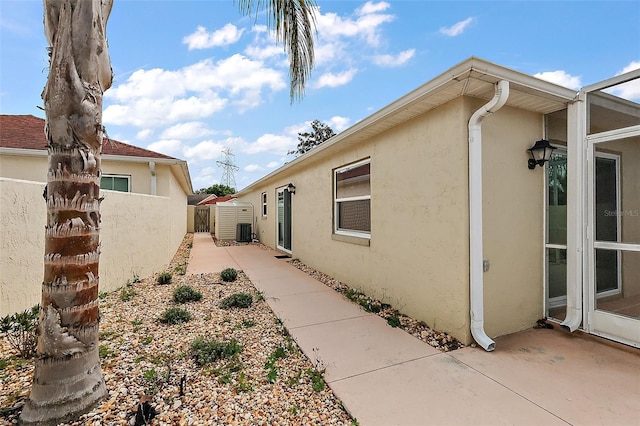 1323 Balboa Ct, The Villages, FL 32159 - view of side of property featuring stucco siding, fence, cooling unit, and a patio area