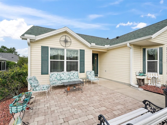 back of property featuring roof with shingles and a patio area