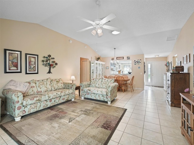 living room with light tile patterned floors, lofted ceiling, and ceiling fan with notable chandelier