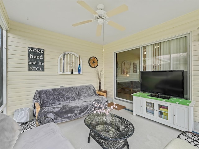 living room with ceiling fan, wood walls, and carpet floors