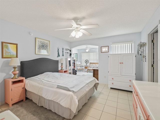 bedroom featuring light tile patterned floors, a textured ceiling, and ceiling fan
