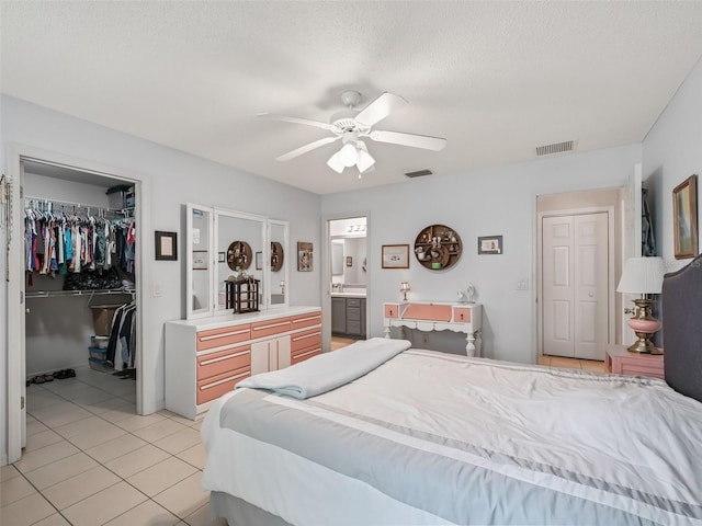 bedroom with light tile patterned floors, visible vents, a spacious closet, and a closet