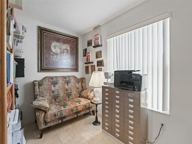 living area with light tile patterned floors and a textured ceiling