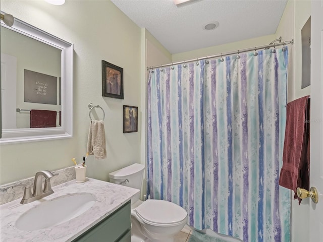 bathroom with a textured ceiling, vanity, toilet, and curtained shower