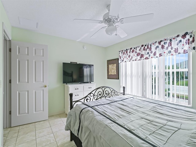tiled bedroom featuring a textured ceiling and a ceiling fan