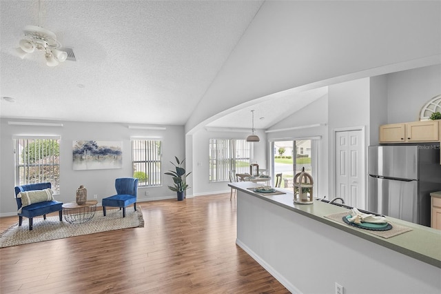 interior space featuring freestanding refrigerator, wood finished floors, and a healthy amount of sunlight