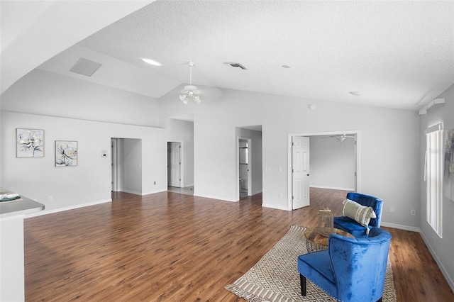 unfurnished living room featuring wood finished floors, vaulted ceiling, ceiling fan, visible vents, and a textured ceiling