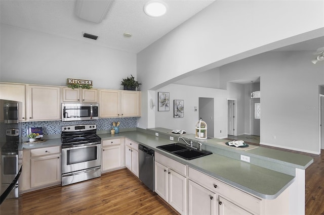 kitchen with tasteful backsplash, a sink, visible vents, stainless steel appliances, and a peninsula