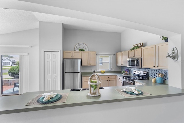 kitchen with lofted ceiling, tasteful backsplash, appliances with stainless steel finishes, light brown cabinets, and plenty of natural light
