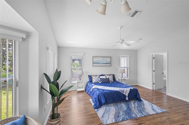 bedroom with visible vents, wood finished floors, and multiple windows