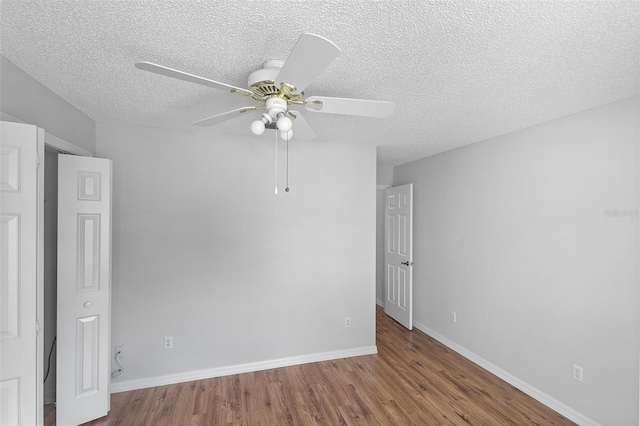 unfurnished bedroom with a textured ceiling, wood finished floors, ceiling fan, and baseboards