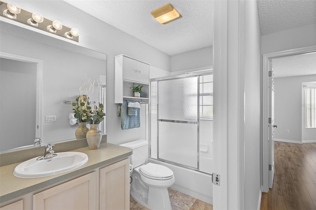 bathroom featuring toilet, a textured ceiling, vanity, and plenty of natural light