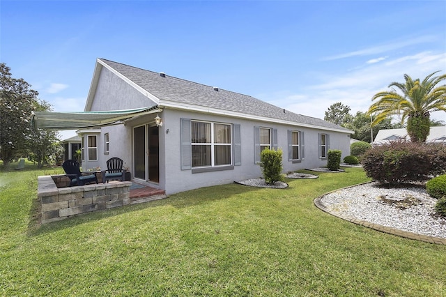 rear view of property featuring a patio, a yard, and stucco siding