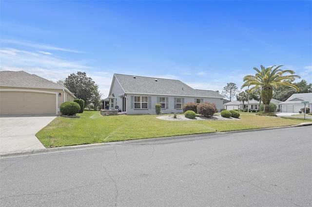 view of front of house with a front lawn, driveway, a garage, and stucco siding