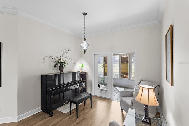 sitting room with ornamental molding, wood finished floors, and baseboards
