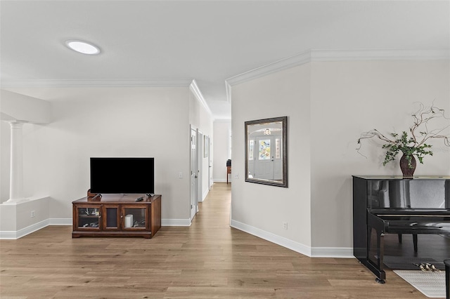 living room with baseboards, decorative columns, wood finished floors, and crown molding