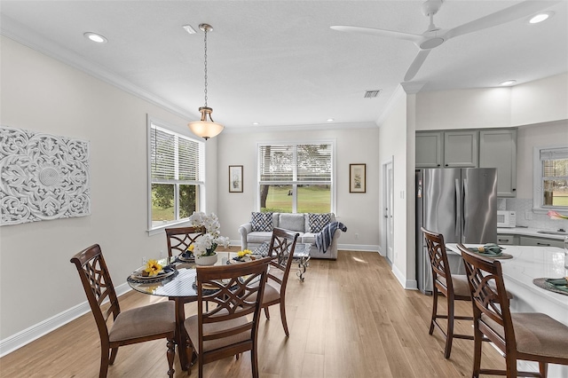 dining space with ornamental molding, visible vents, and a wealth of natural light