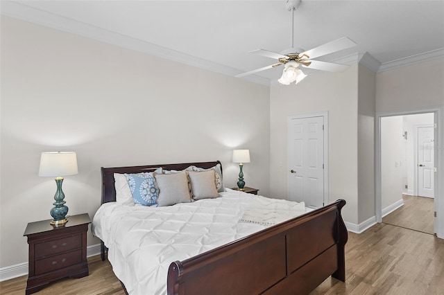 bedroom with crown molding, a ceiling fan, wood finished floors, and baseboards