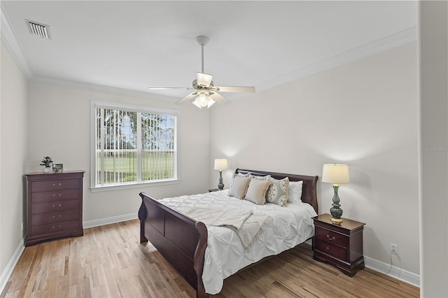 bedroom featuring ornamental molding, visible vents, wood finished floors, and baseboards
