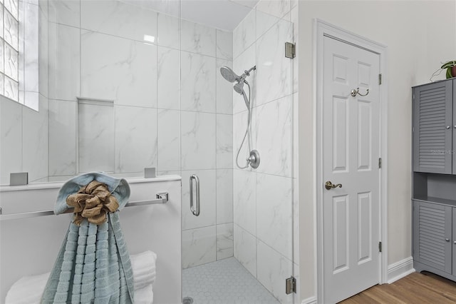 full bathroom with wood finished floors and a shower stall