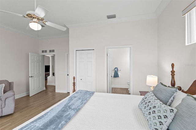 bedroom featuring baseboards, visible vents, wood finished floors, and crown molding