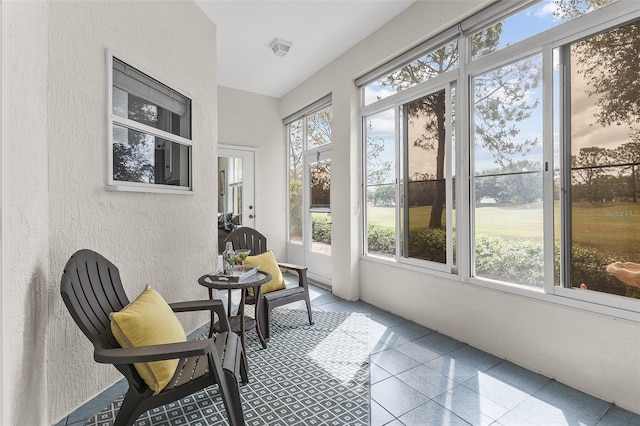 sunroom / solarium with tile patterned flooring and a textured wall