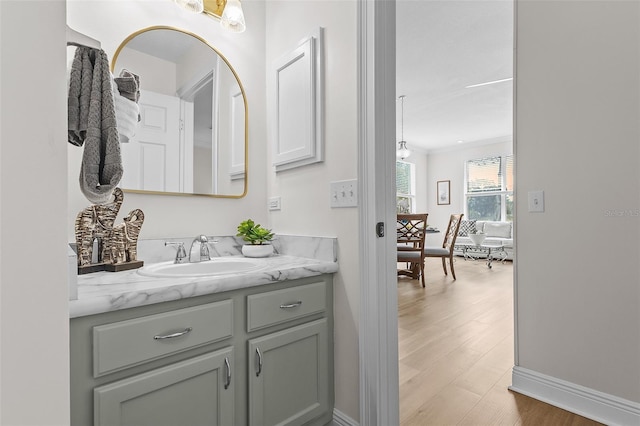 bathroom with vanity, wood finished floors, and baseboards