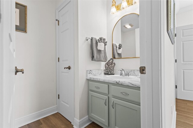 bathroom featuring wood finished floors, vanity, and baseboards