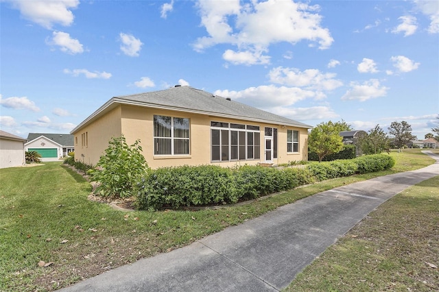 view of side of property featuring stucco siding and a yard