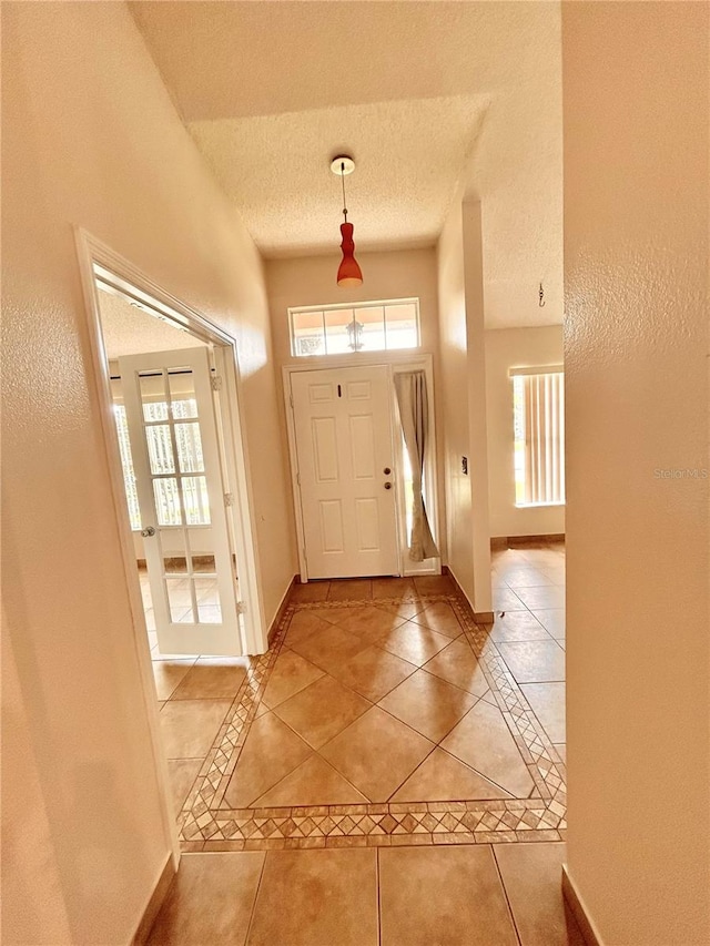 1307 Rain Forest Ln, Minneola, FL 34715 - entryway featuring light tile patterned flooring, a textured ceiling, and inlaid floor details