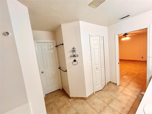 1307 Rain Forest Ln, Minneola, FL 34715 - hallway featuring a textured ceiling and light tile patterned floors
