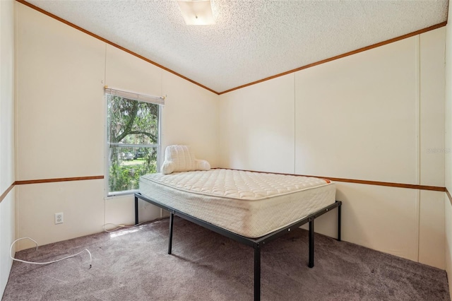 carpeted bedroom featuring ornamental molding, a textured ceiling, and vaulted ceiling