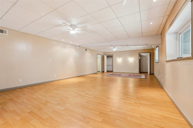 spare room featuring baseboards, ceiling fan, and light wood-type flooring
