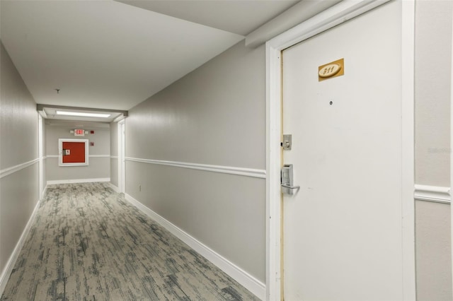 hall with baseboards and wood finished floors