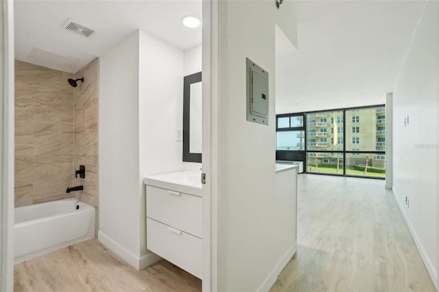 full bathroom featuring vanity, wood finished floors,  shower combination, visible vents, and electric panel