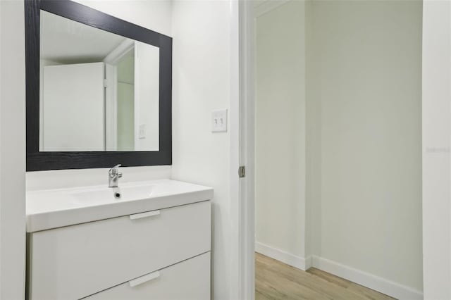 bathroom with baseboards, vanity, and wood finished floors