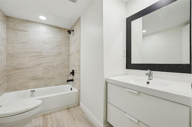 bathroom featuring vanity, toilet, baseboards, tub / shower combination, and wood finished floors