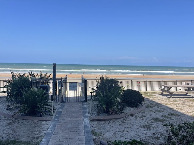 property view of water featuring fence and a view of the beach