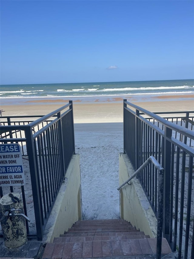 surrounding community with a water view and a view of the beach