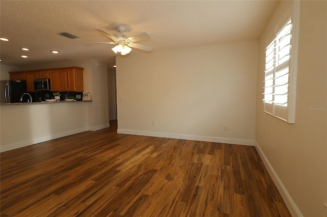 unfurnished living room featuring visible vents, baseboards, dark wood-type flooring, recessed lighting, and a ceiling fan