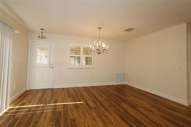 unfurnished dining area featuring a notable chandelier, wood finished floors, and visible vents