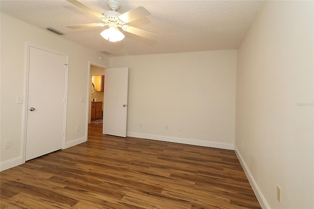 unfurnished bedroom with ceiling fan, a textured ceiling, visible vents, wood finished floors, and baseboards