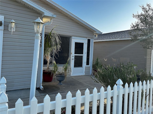 doorway to property featuring fence