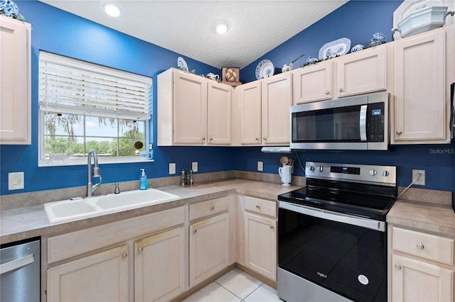 8097 SE 174th Belhaven Loop, The Villages, FL 32162 - kitchen featuring stainless steel appliances, a sink, light countertops, a textured ceiling, and light tile patterned flooring